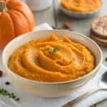 A side-by-side photo of two cans from a grocery store shelf: one labeled "100% Pure Pumpkin" and the other labeled "Pumpkin Pie Filling" or "Easy Pumpkin Pie Mix," highlighting the difference between the two products.